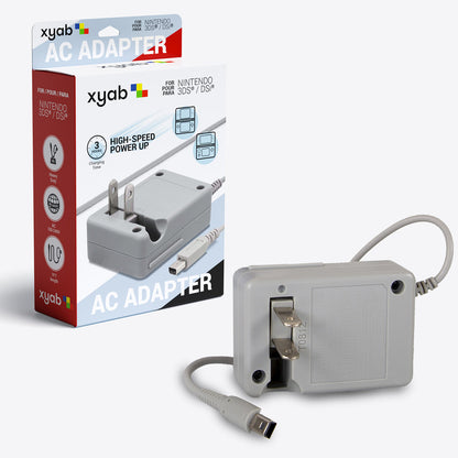 A Nintendo DS/3DS handheld charger in white color, with a power cord, packaged in a gray box with red, yellow, and green accents.
